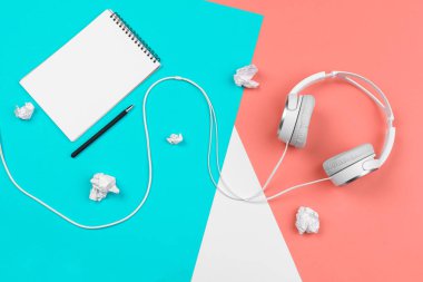 Parlak renk bloğu arka planında kablosu olan kulaklıklar