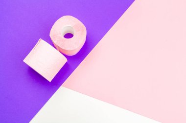 Parlak renk bloğu arka planında Pastel pembe tuvalet kağıdı