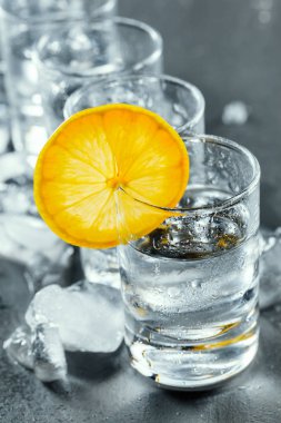 Siyah arka planda shot bardaklarında soğuk votka..