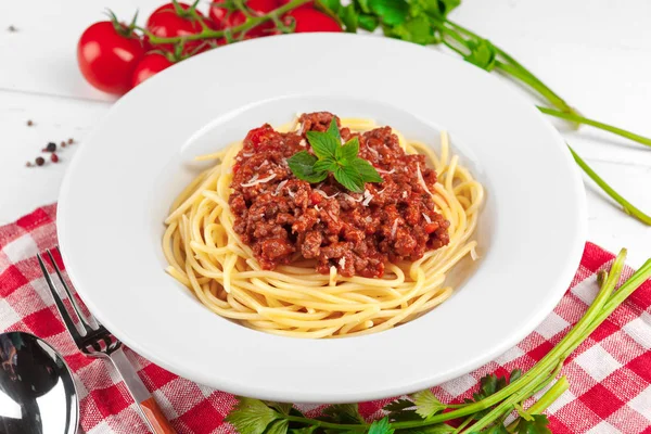 Pasta with meat, tomato sauce and vegetables on the table