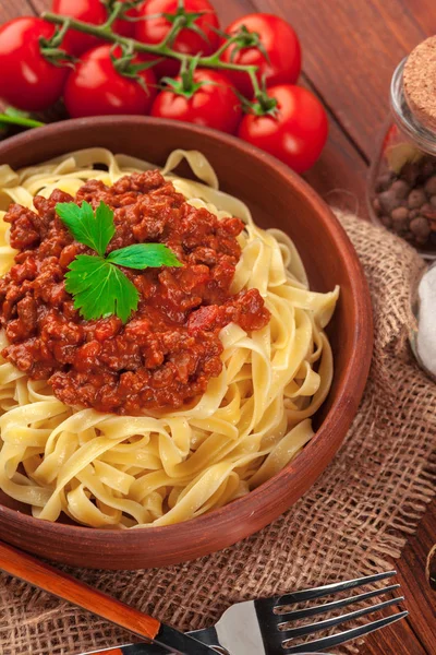 Pasta with meat, tomato sauce and vegetables on the table