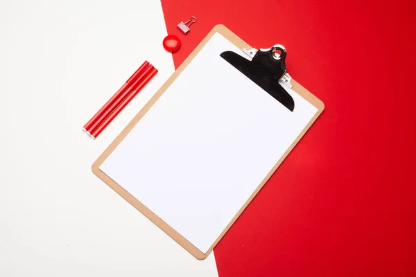 Blank clipboard paper on red and white paper background