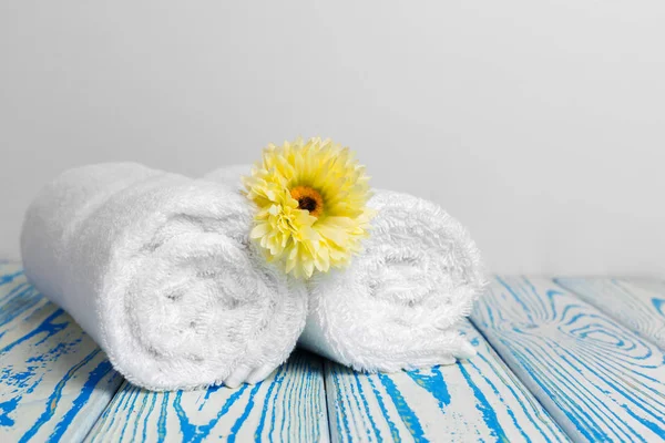 clean soft towels with flower on wooden table