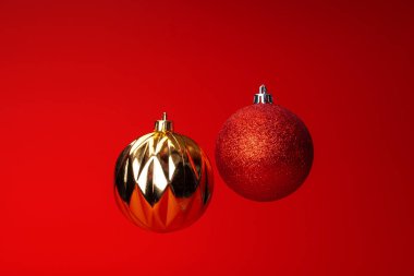 Kırmızı arka plan üzerinde havada noel bauble levitating. Noel kartı