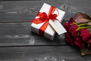 Masada bir buket kırmızı gül, hediye ve kalp. Konsept Kadınlar Günü veya St Valentine. Kopyalama alanı