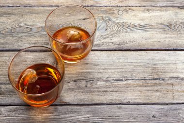 Bir bardak buzlu viski, bir şişe de ahşap çubukta. 