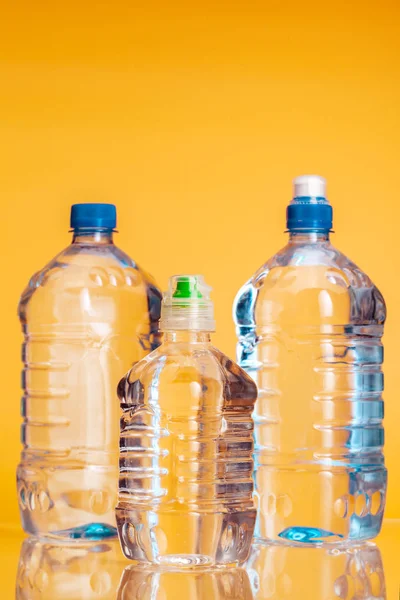 Plastic bottle of mineral water on a bright yellow background