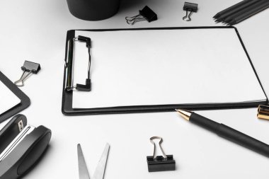 Beyaz arkaplan üzerinde beyaz sayfa ve kalem olan bir pano. Üst görünüm