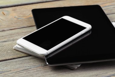 dijital tablet ve akıllı telefon masada.