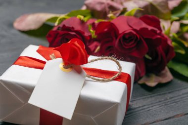 Masada bir buket kırmızı gül, hediye ve kalp. Konsept Kadınlar Günü veya St Valentine. Kopyalama alanı