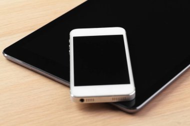 dijital tablet ve akıllı telefon masada.
