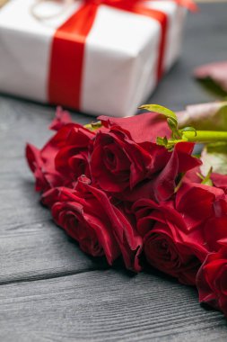 Masada bir buket kırmızı gül, hediye ve kalp. Konsept Kadınlar Günü veya St Valentine. Kopyalama alanı
