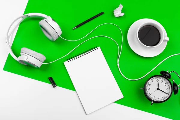 White headphones with cord on bright green background