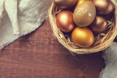 Ahşap arka planda altın Paskalya yumurtaları