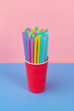 Renkli arka planda meşrubat için renkli pipetler
