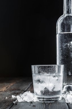 Kırsal ahşap arka planda shot bardaklarında votka