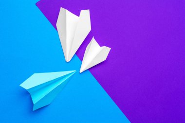 Beyaz kağıt uçak mavi ve mor kağıt arka planda