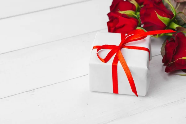 バレンタインデー 木製のテーブルの上の赤いバラとギフトボックス — ストック写真