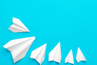 Mavi arka planda beyaz kağıt uçak