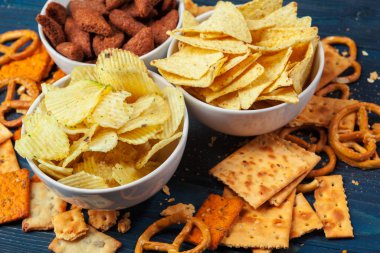 Mavi ahşap arka planda çeşitli bira aperatifleri