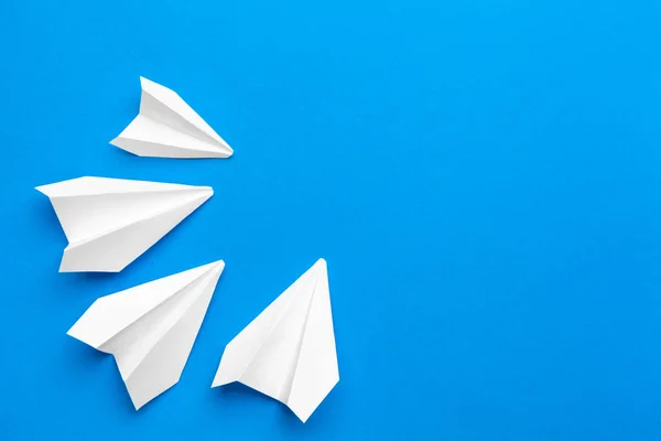 white paper airplane on a navy paper background