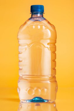 Parlak sarı arka plan üzerinde maden suyu Plastik şişe