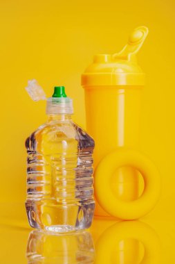 Parlak sarı arka plan üzerinde maden suyu Plastik şişe