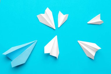 Mavi arka planda beyaz kağıt uçak