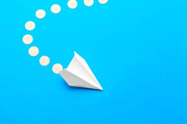 Beyaz kağıt uçağın düz yatağı ve pastel mavi arkaplan üzerine boş kağıt