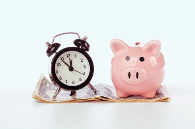 Para yığını üzerinde saat ile Piggy banka.