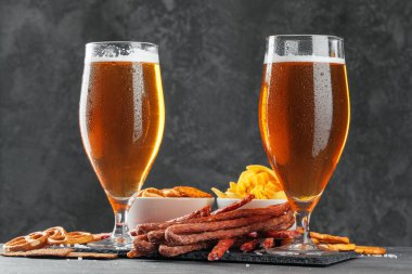  Bira ve aperatif bira seti. Bir kupa biralı masa, sosisli ahşap tahta.