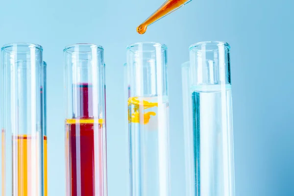 Tubos Ensaio Laboratório Com Líquidos Vermelhos Amarelos Sobre Fundo Azul — Fotografia de Stock