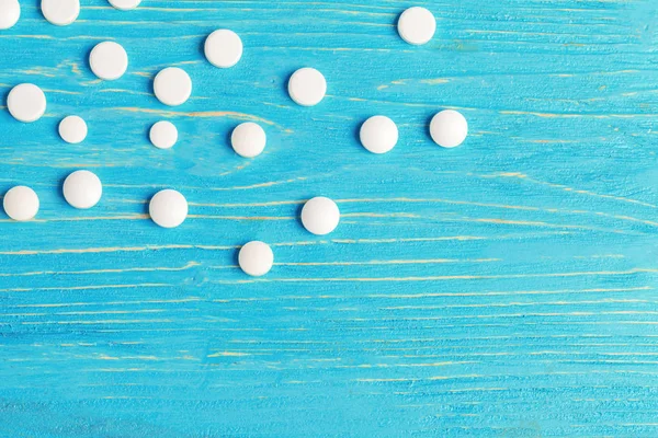 Jasně Modré Dřevěné Pozadí Rozlité Bílé Tablety — Stock fotografie