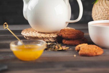 Ahşap masada bir fincan siyah çay ile camdan bir çaydanlık.