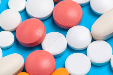 Mavi arkaplanda çok renkli tabletler ve kapsüller