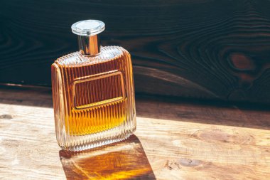 Ahşap arka planda parfüm şişeleri püskürtücü