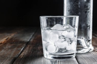 Kırsal ahşap arka planda shot bardaklarında votka
