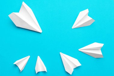 Mavi arka planda beyaz kağıt uçak