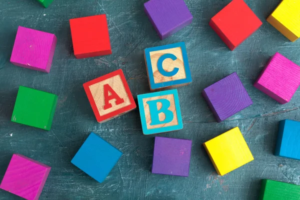 Alphabet blocks ABC on wooden table.