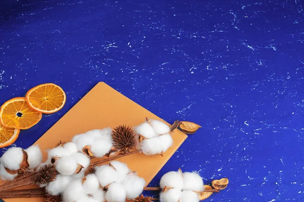 Flat lay of feminine blue background with branch of artificial cotton flower