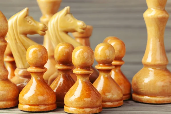 Frame of chess pieces on a rustic wooden background