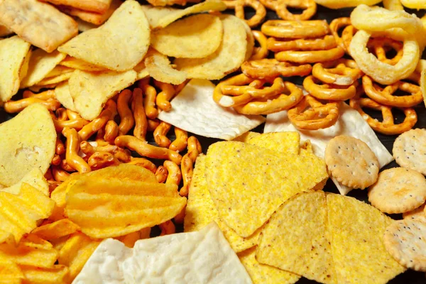 零食的混合物 桌上的椒盐饼干 薯片和玉米片 — 图库照片