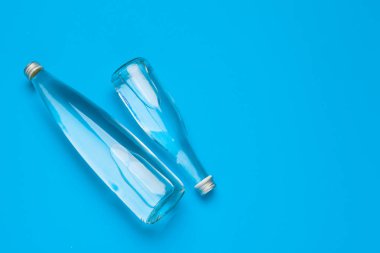 Mavi arka plan üst görünümünde boş su şişesi