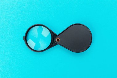 Mavi pastel arka plan üzerinde büyüteç.