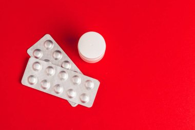 Kırmızı arka planda su toplayan haplar. İlaç.