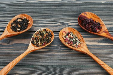 Ahşap bir tahta üzerinde tahta kaşık otlar ile Siyah çay 