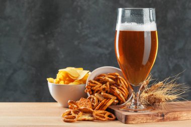 Beer glass with bretzel and dried sausages snacks close up clipart