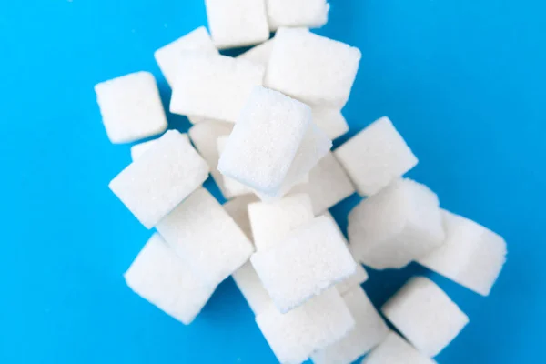 White sugar cubes on a bright blue background