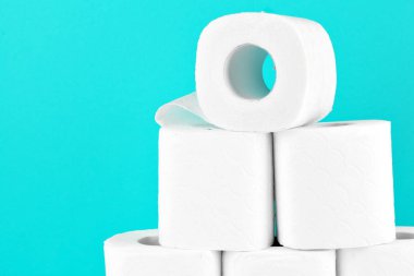 Turkuazın parlak arka planında tuvalet kağıdı ruloları