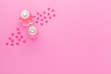 Pembe arka planda parfüm şişeleri